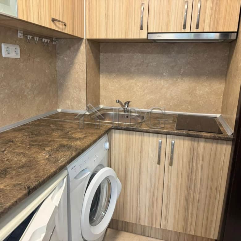 Compact kitchen with washing machine and wooden cabinets in Cascadas Complex, Sunny Beach.