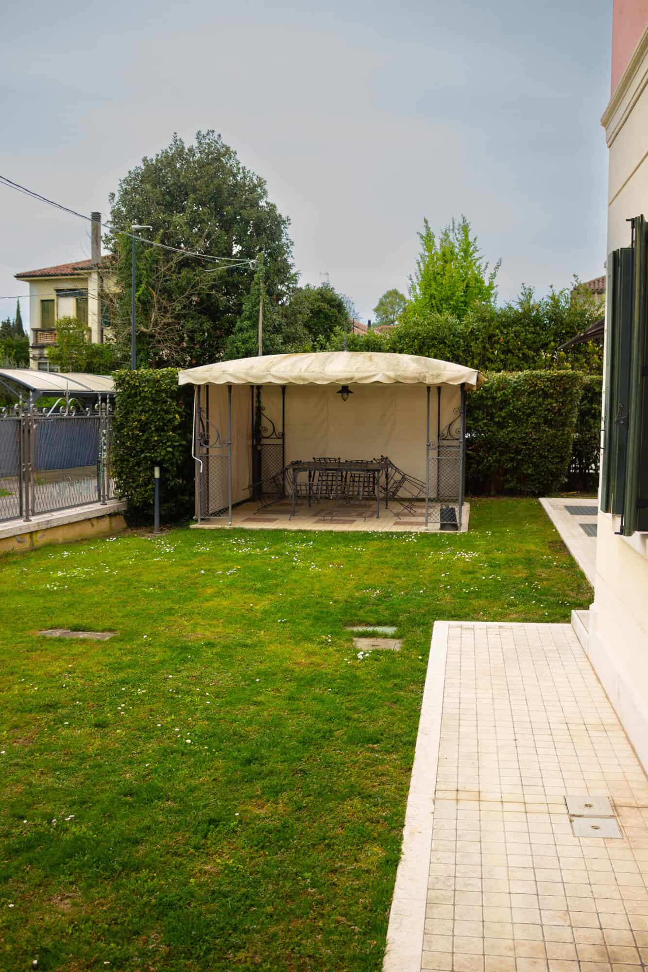 Gazebo with seating area in a well-maintained garden.