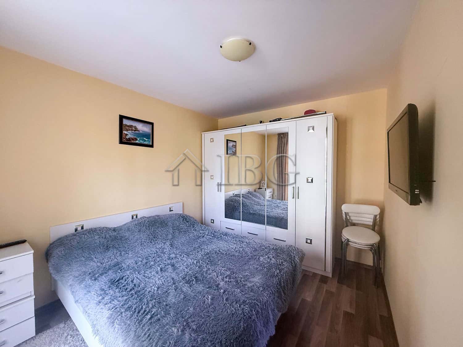 Apartment interior with a double bed, wardrobe, and TV in Sunny Beach, Bulgaria.