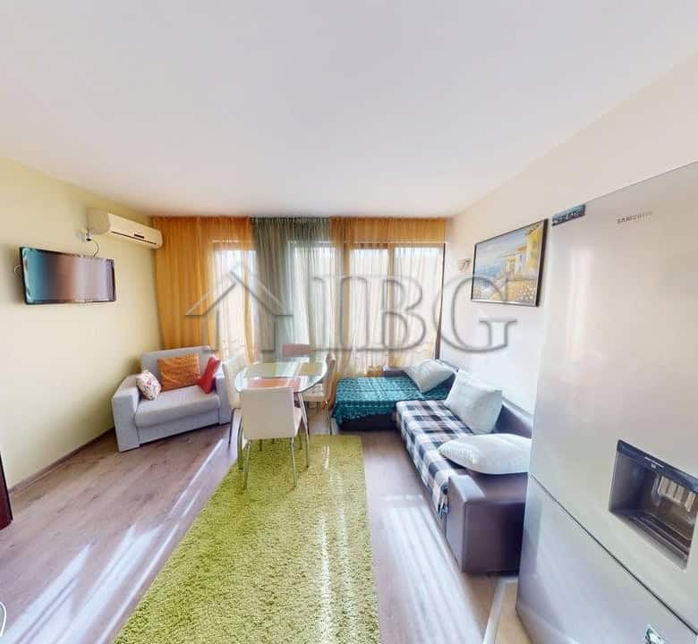 Bright living room with pool view, featuring a sofa, armchair, and large windows in Sunny Beach.