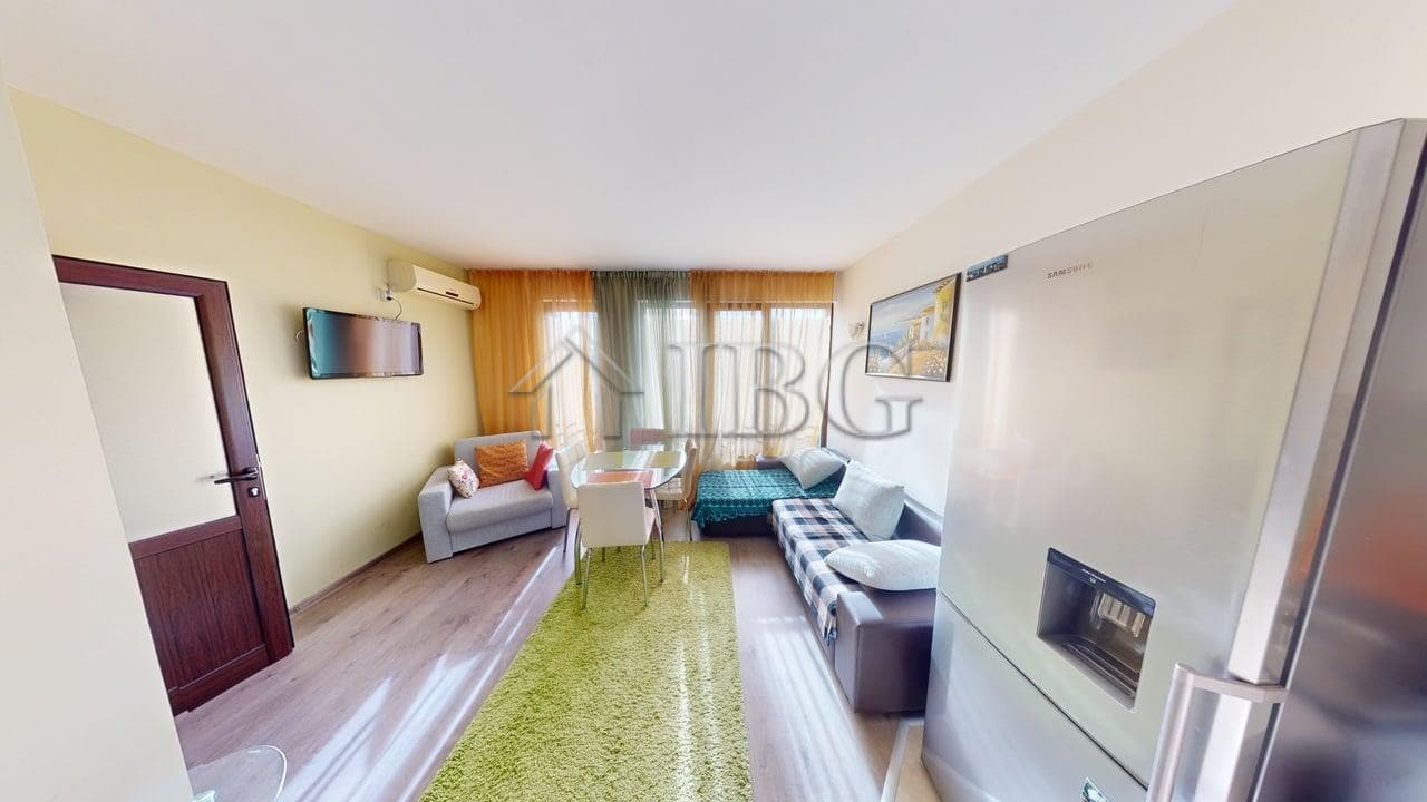 Bright living room with pool view, featuring a sofa, armchair, and large windows in Sunny Beach.