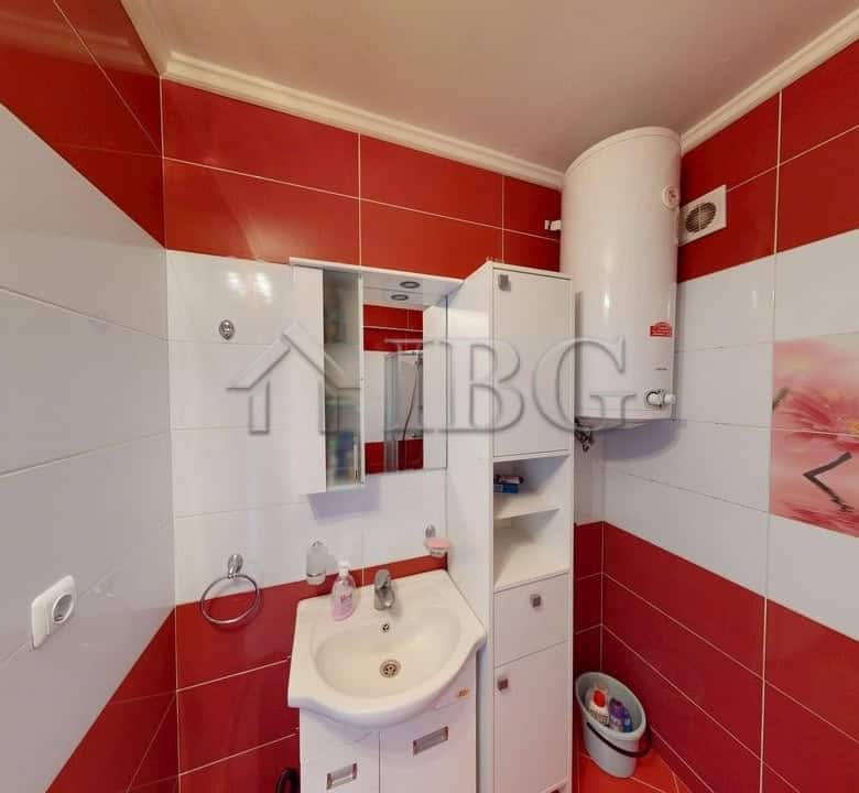 Interior of a one-bedroom apartment with pool view, featuring modern bathroom fixtures and vibrant r.