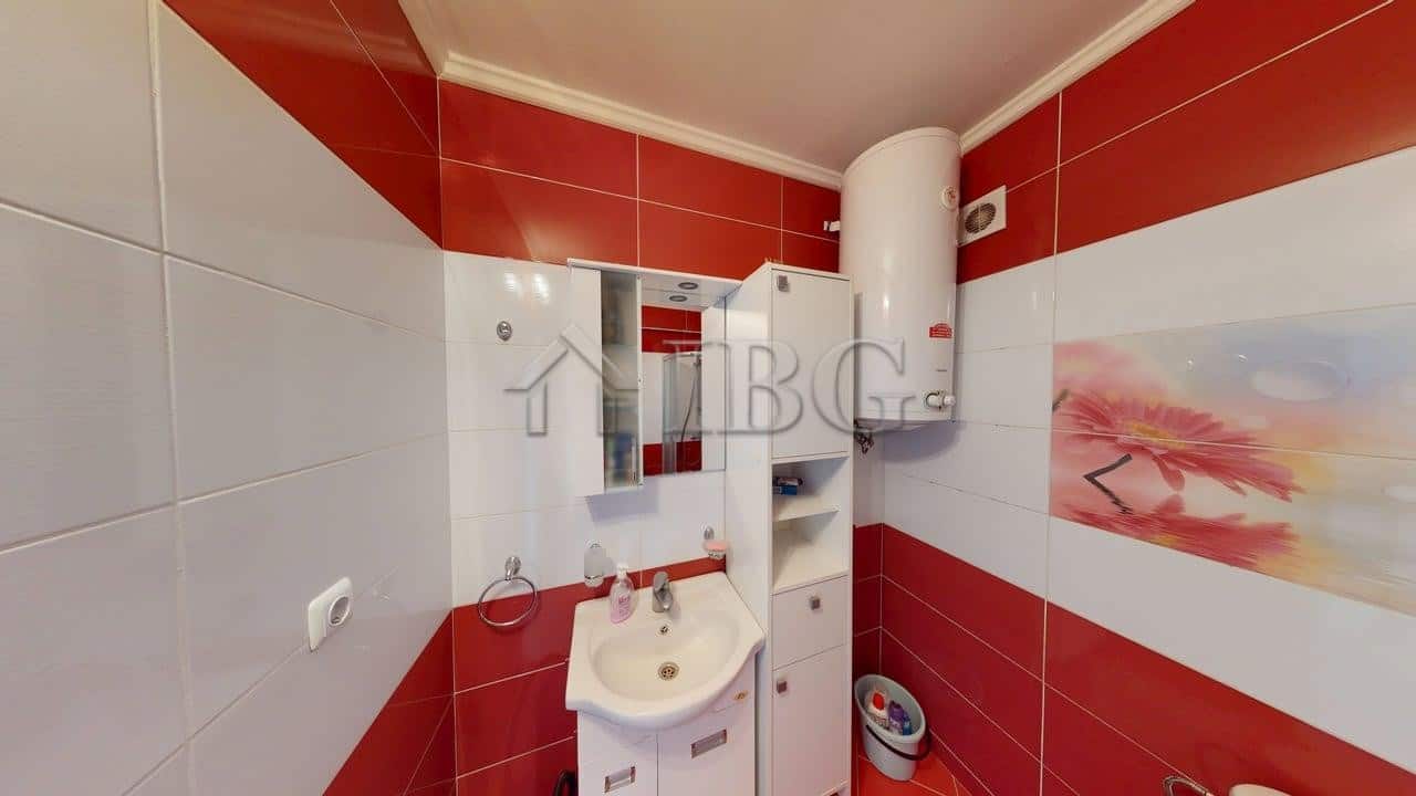 Interior of a one-bedroom apartment with pool view, featuring modern bathroom fixtures and vibrant r.