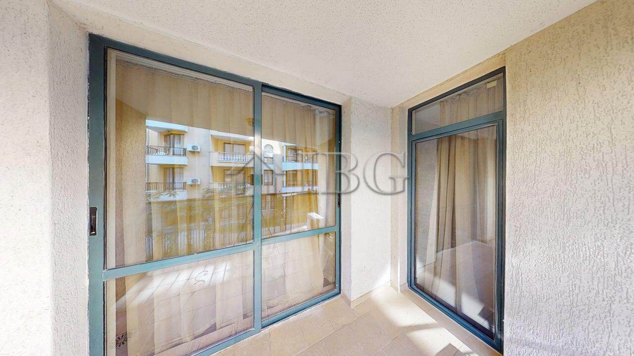 Balcony view of a one-bedroom apartment in Avalon, Sunny Beach, with glass sliding doors and outdoor.