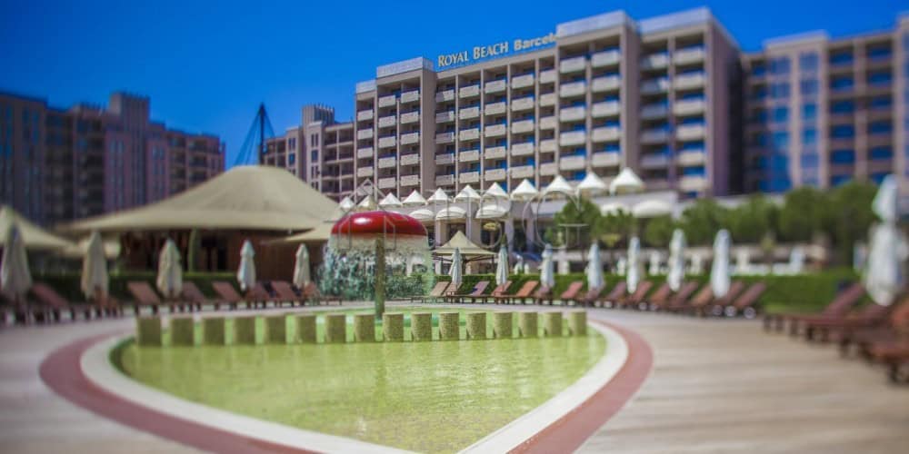 Pool area with sun loungers and umbrellas at Barceló Royal Beach hotel, overlooking the sea.