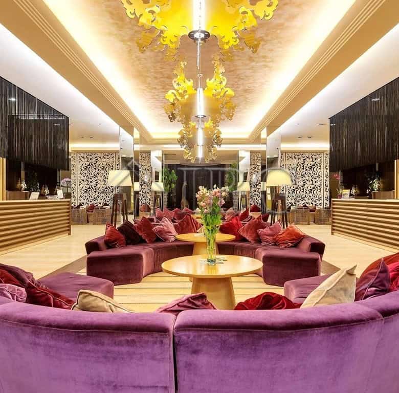 Elegant hotel lobby featuring plush purple seating and modern design elements.