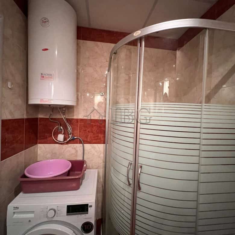 Bright bathroom with shower cabin and washing machine in Sveti Vlas.