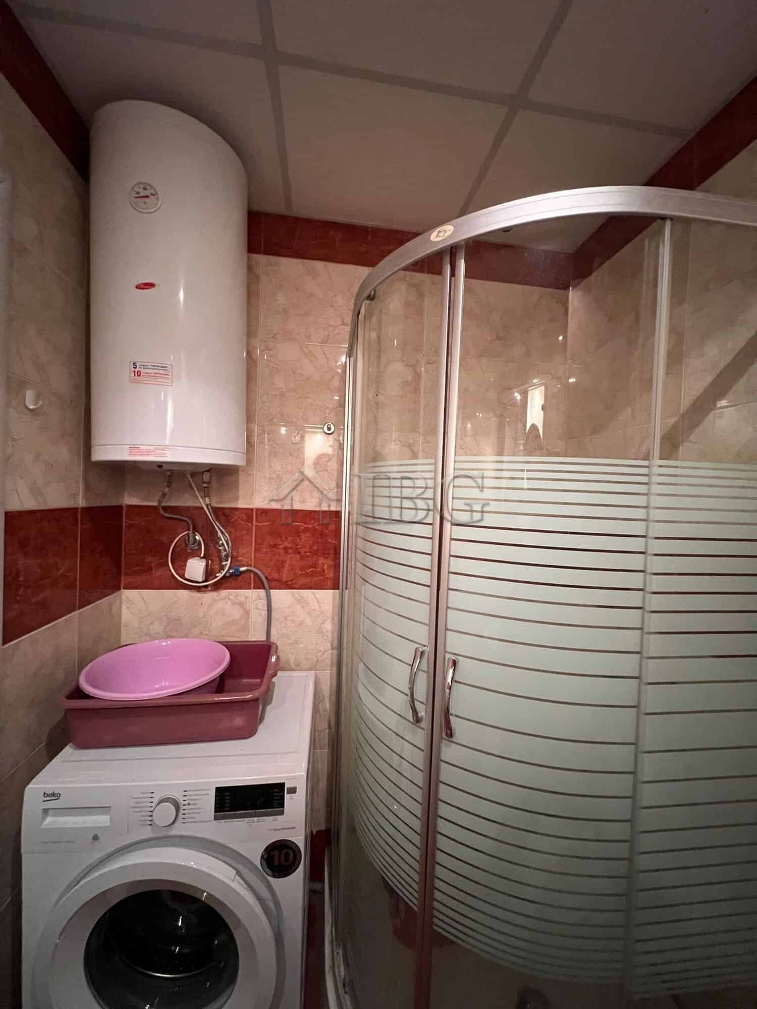 Bright bathroom with shower cabin and washing machine in Sveti Vlas.