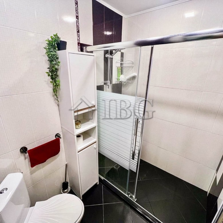 Bright bathroom with shower enclosure and modern fixtures in Burgas Beach Resort.