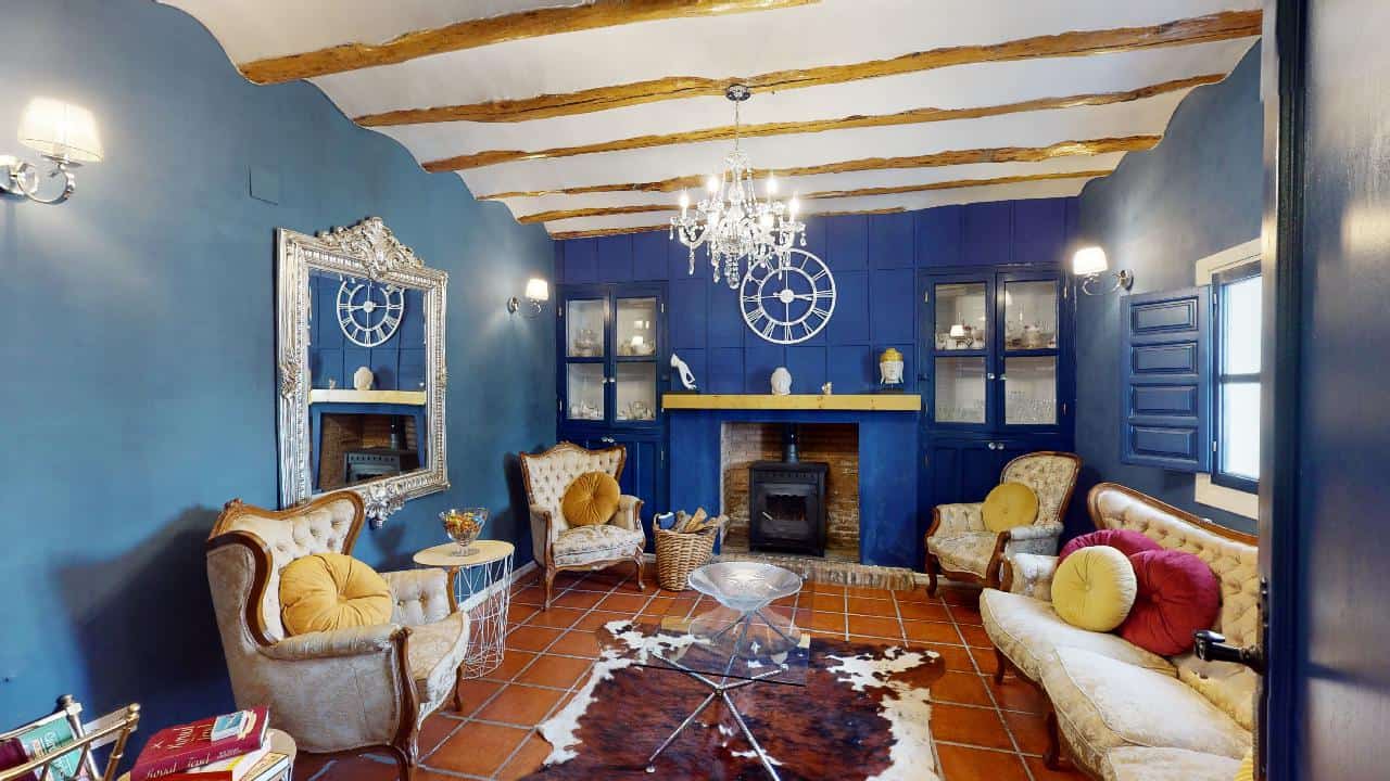 Charming boutique hotel living room with vibrant blue walls, elegant furniture, and rustic wooden ce.