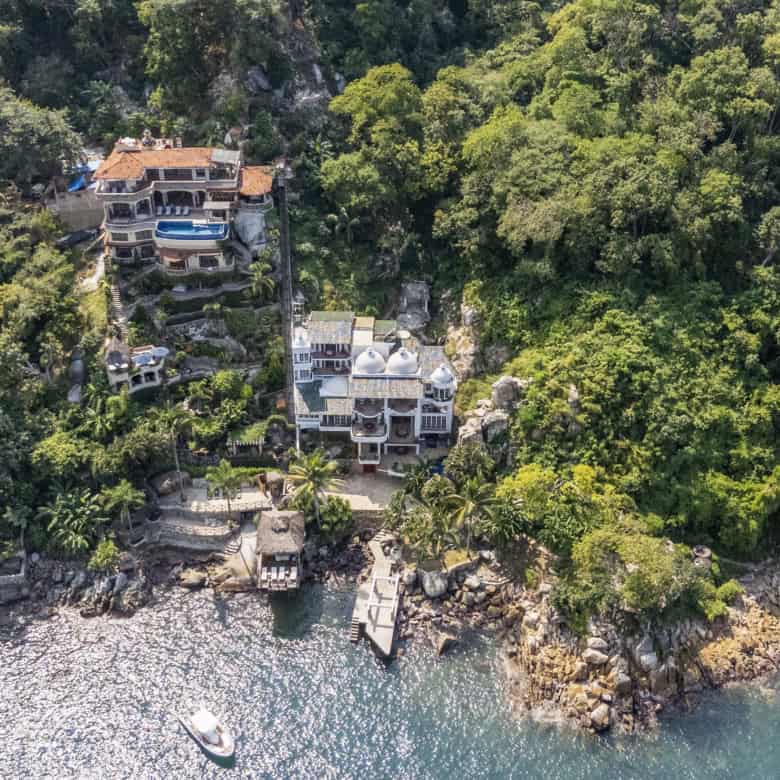 Luxury waterfront homes on a lush green coastline.