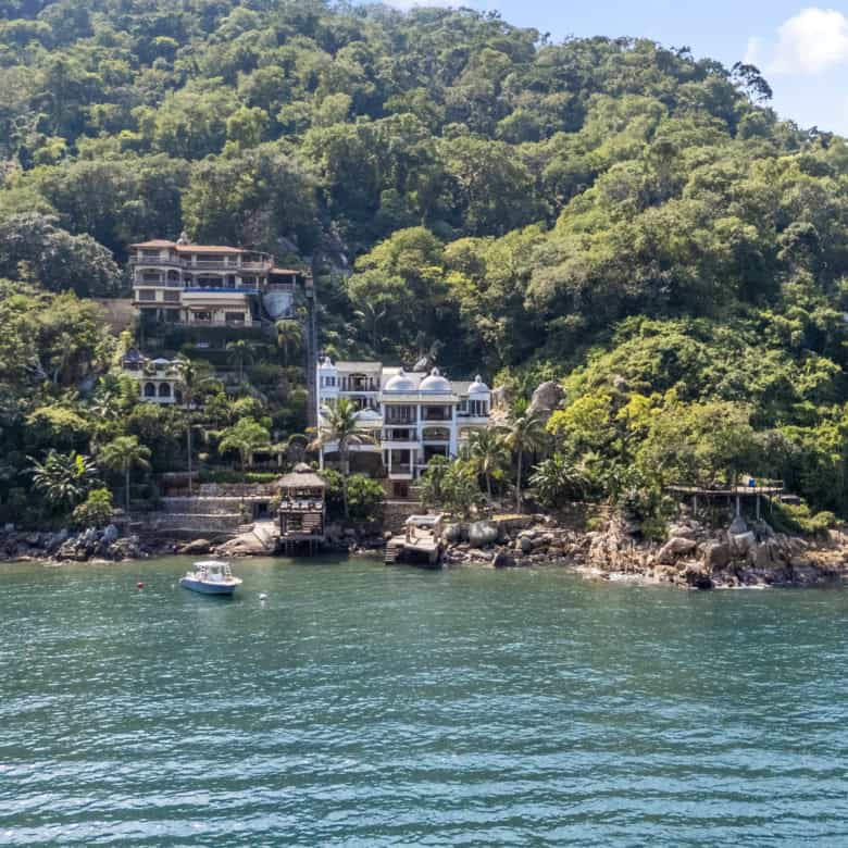 Seaside homes nestled on lush green hills overlooking the water.