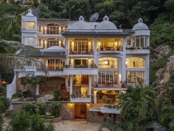 Elegant hillside villa with stunning ocean views and lush tropical surroundings.
