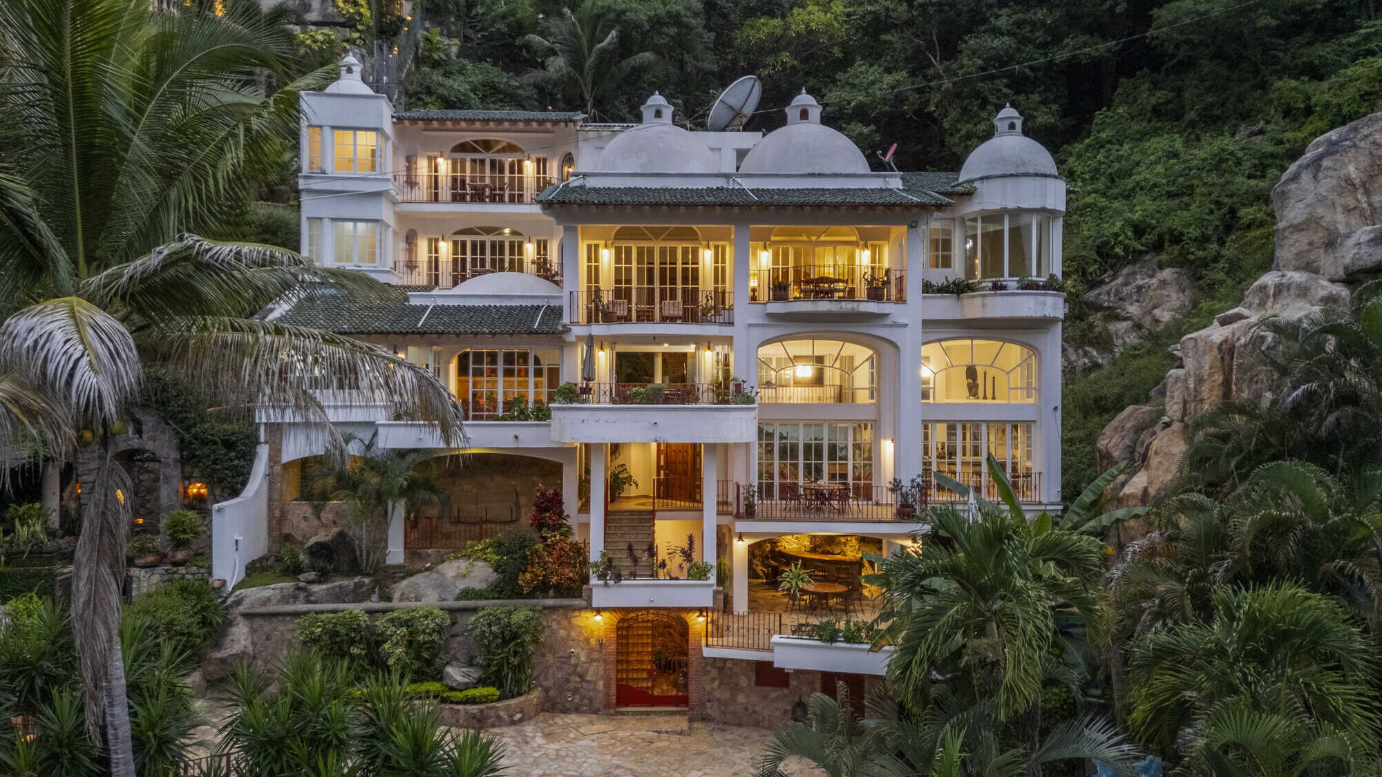 Elegant hillside villa with stunning ocean views and lush tropical surroundings.