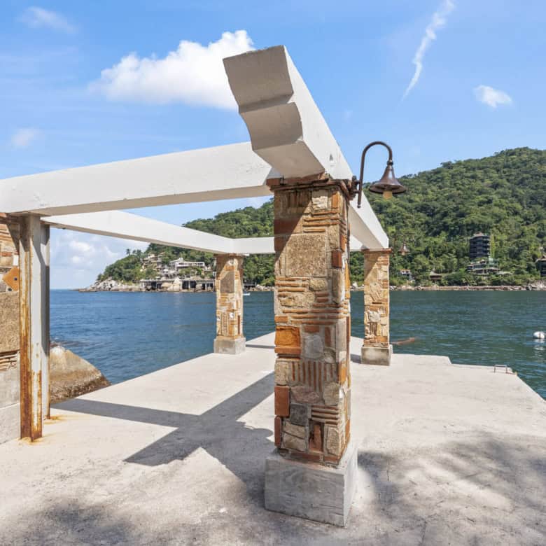 Beachside pier with wooden beams and brick supports overlooking the water.