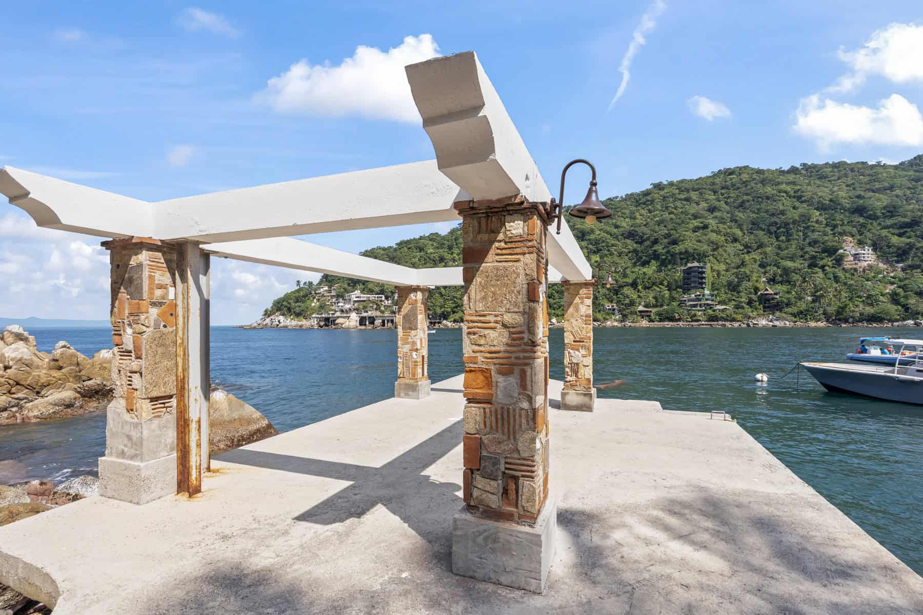 Beachside pier with wooden beams and brick supports overlooking the water.