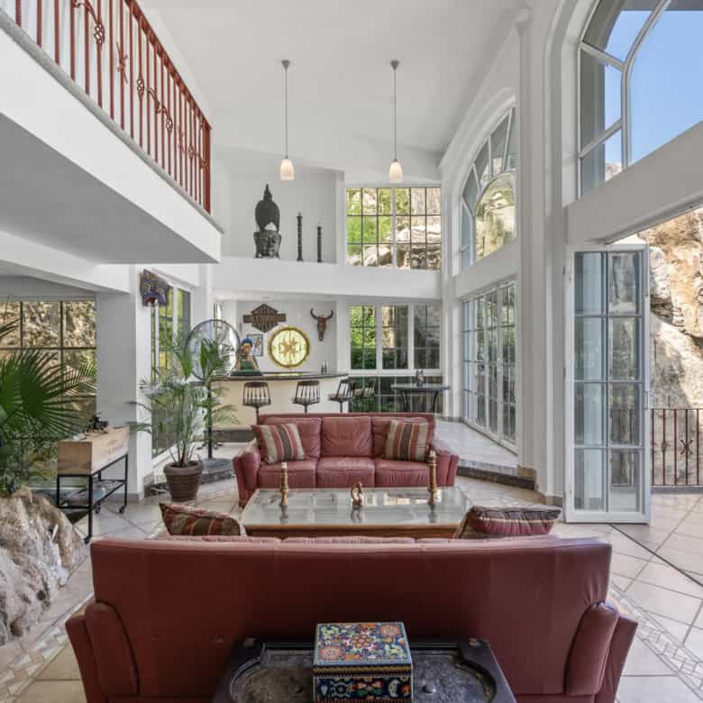 Bright, spacious living area with large windows and natural rock accents.
