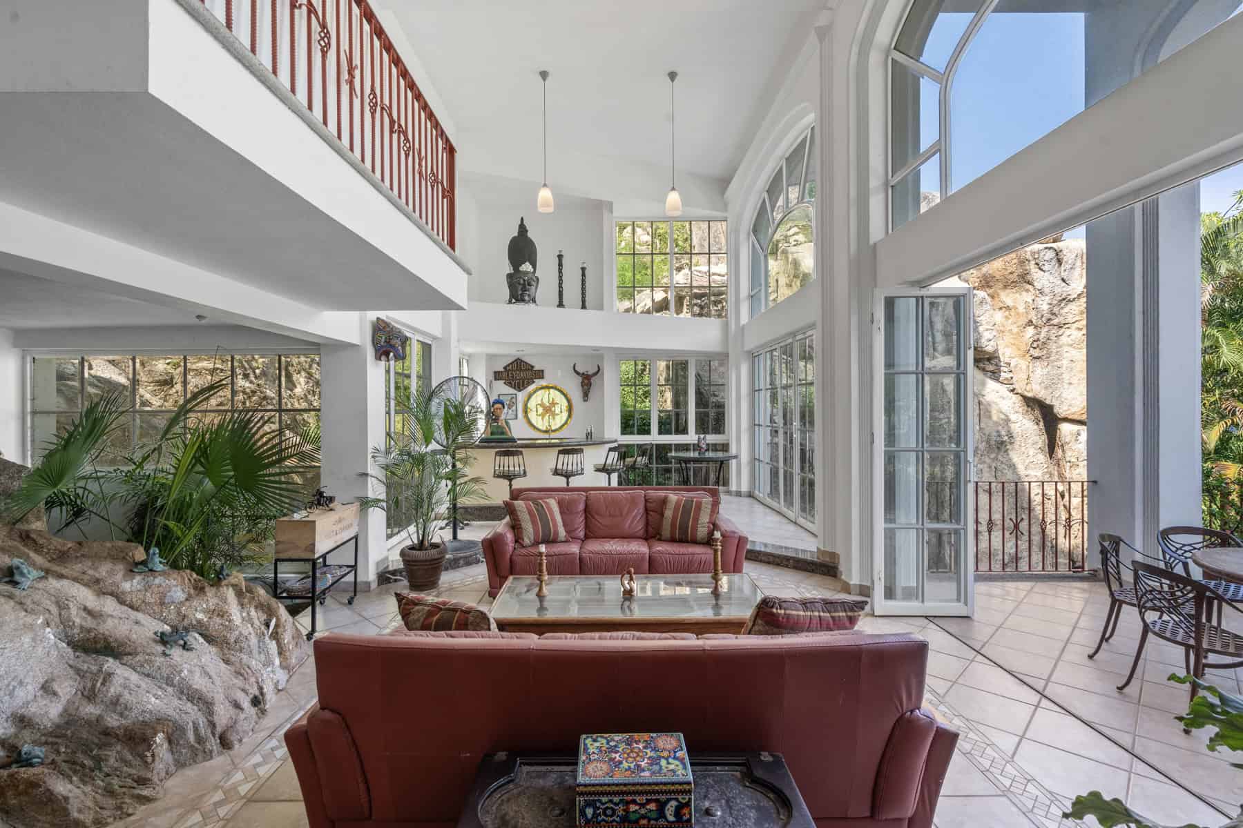 Bright, spacious living area with large windows and natural rock accents.