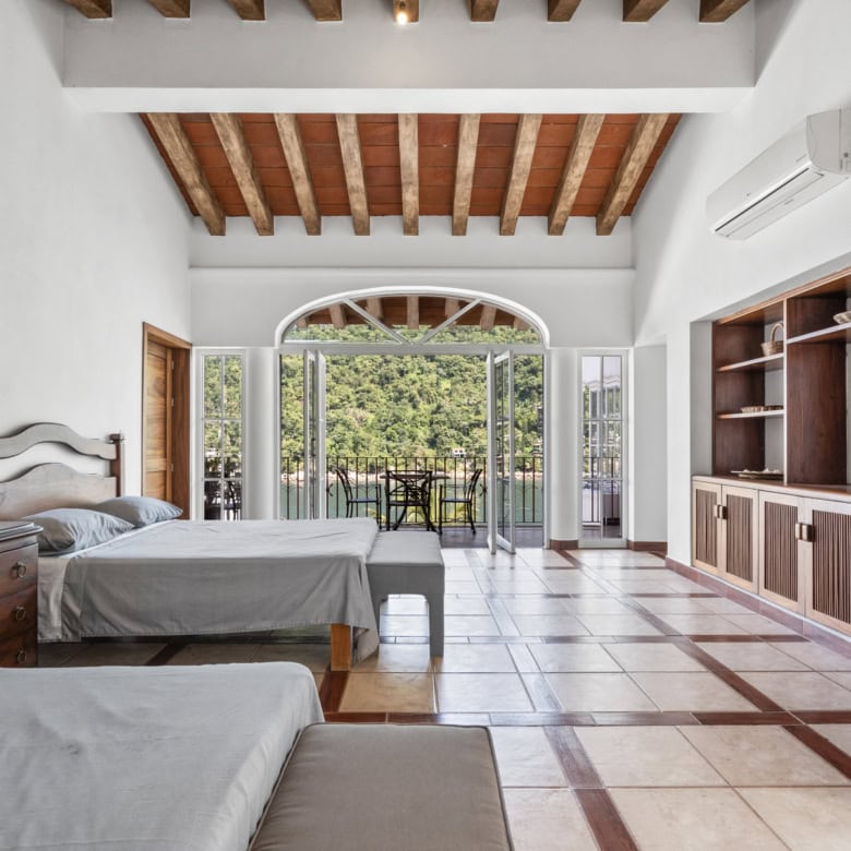 Modern bedroom with balcony and wooden ceiling.
