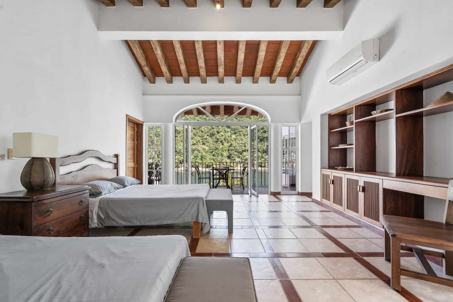 Modern bedroom with balcony and wooden ceiling.