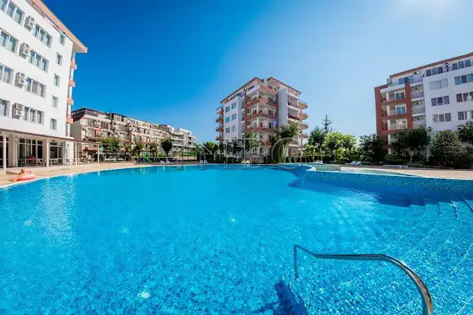Apartment with swimming pool and cityscape background.