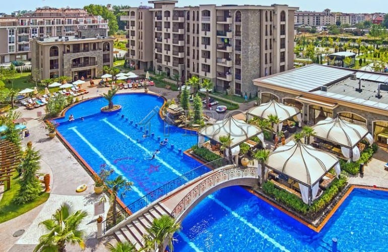 Beautiful outdoor pool with sun loungers and shaded seating areas at Cascadas Complex, Sunny Beach.