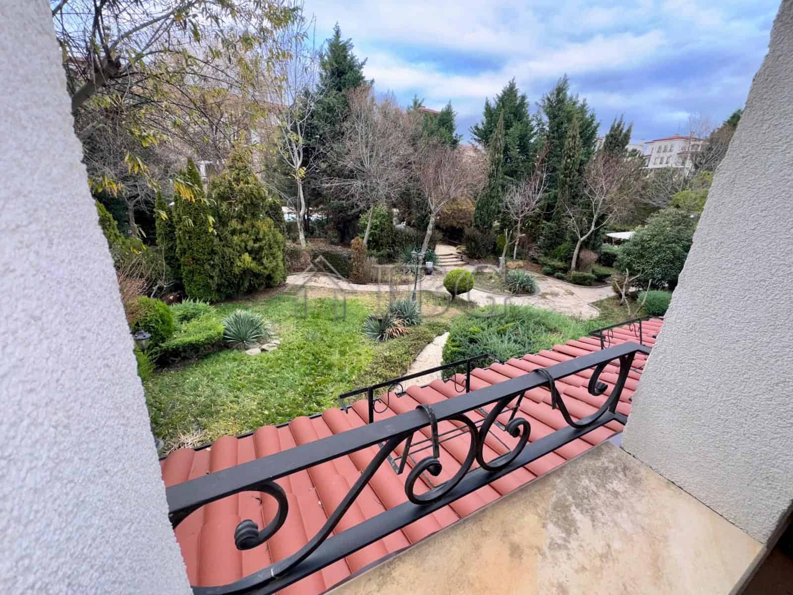 Bright balcony view of lush garden and trees in Nessebar.
