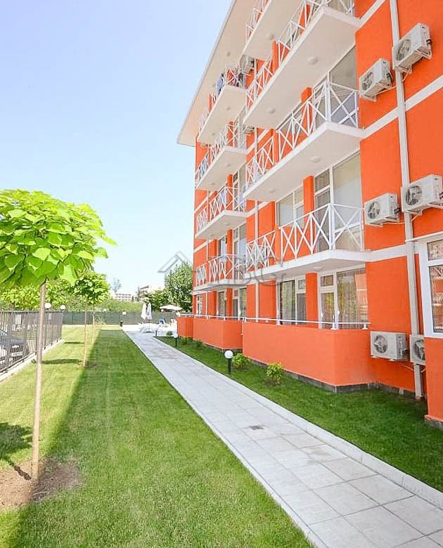 Bright orange modern apartment building with balconies in Sunny Beach, Bulgaria.