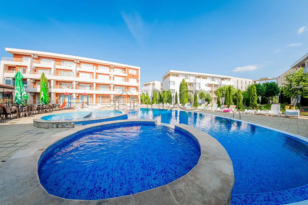 Bright sunny day at Holiday Fort Golf Club with swimming pool and surrounding lounge area in Sunny B.