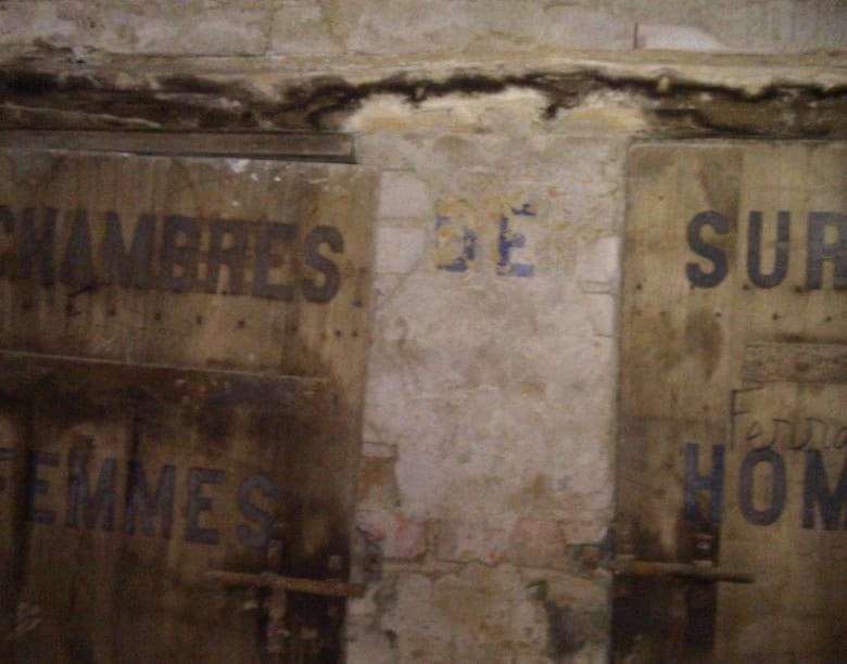 Historic signs for women's and men's chambers in an old building in Oradour Sur Vayres, Limousin, Fr.