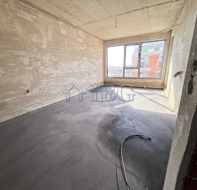 Unfinished interior of a 1-bedroom apartment in Pomorie with large window and natural light.