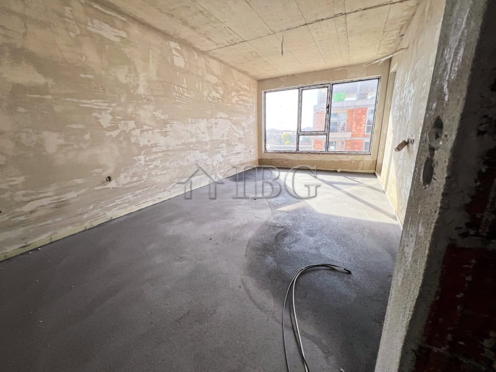 Unfinished interior of a 1-bedroom apartment in Pomorie with large window and natural light.