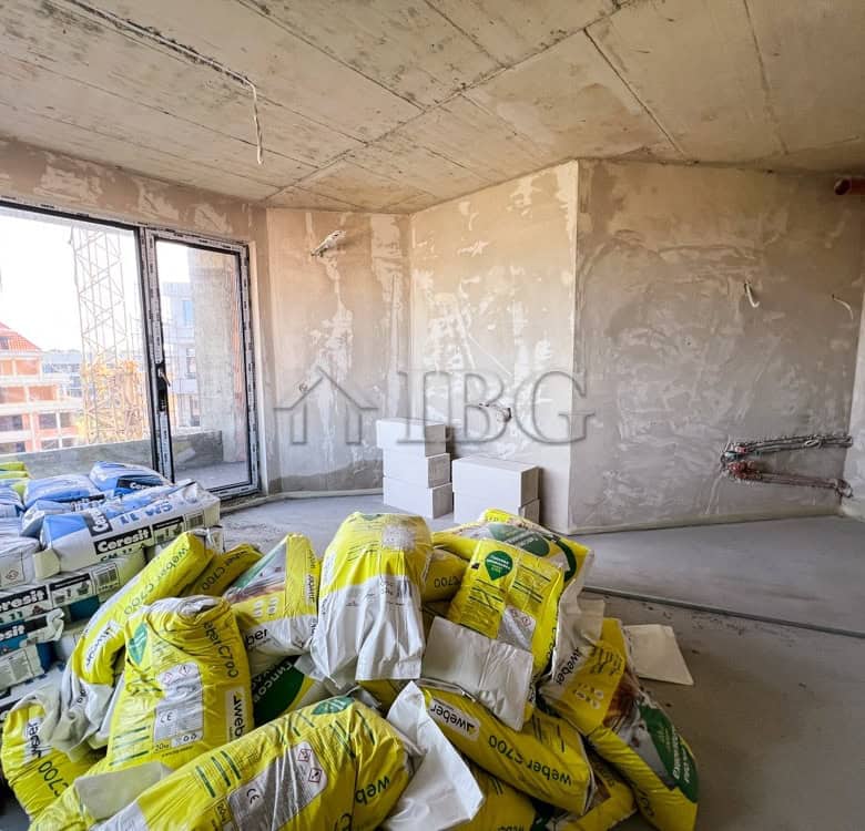 Unfinished 1-bedroom apartment with large window and construction supplies in Pomorie.