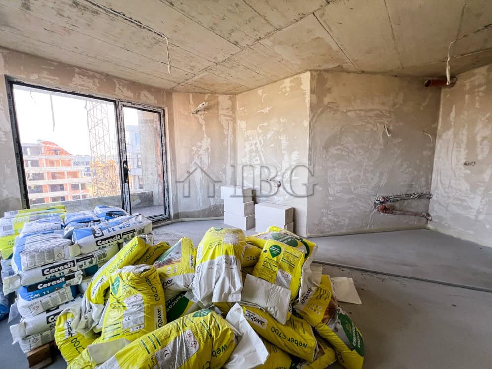 Unfinished 1-bedroom apartment with large window and construction supplies in Pomorie.