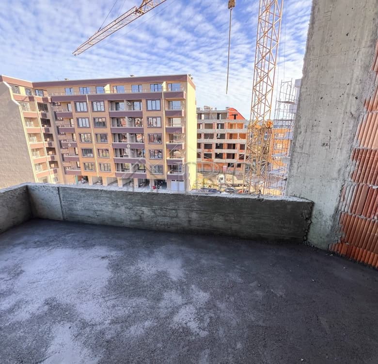 Balcony of a 1-bedroom apartment overlooking Pomorie cityscape, under construction in a new resident.