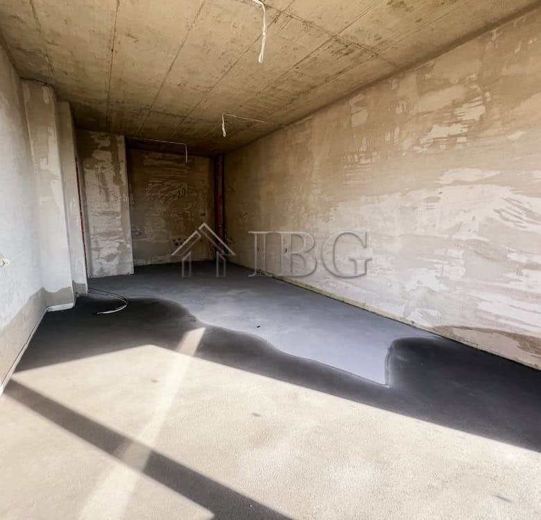 Unfinished apartment space with concrete walls and floor, ready for interior finishing.