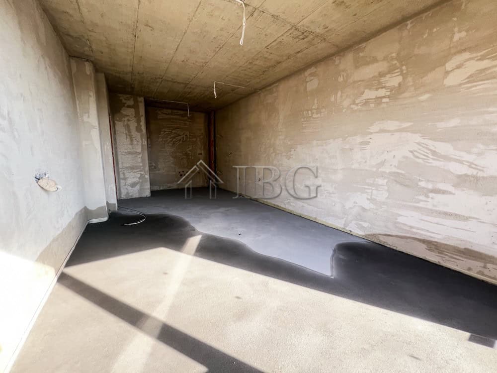 Unfinished apartment space with concrete walls and floor, ready for interior finishing.