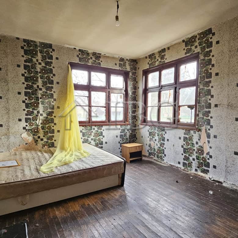 Interior of a house with large windows and a wooden floor in Gyulyovtsa Village, Burgas Region.