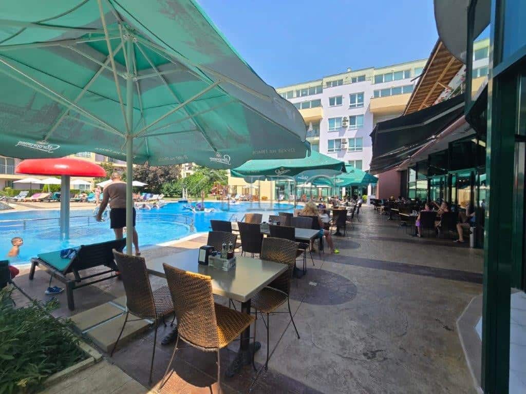 Poolside dining at Pollo Resort in Sunny Beach Poolside dining area with tables, chairs, and umbrellas at Pollo Resort, Sunny Beach.
