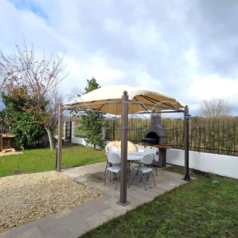 Beautiful outdoor garden area of a luxury villa in Victoria Hill, Pomorie, with a shaded seating are.
