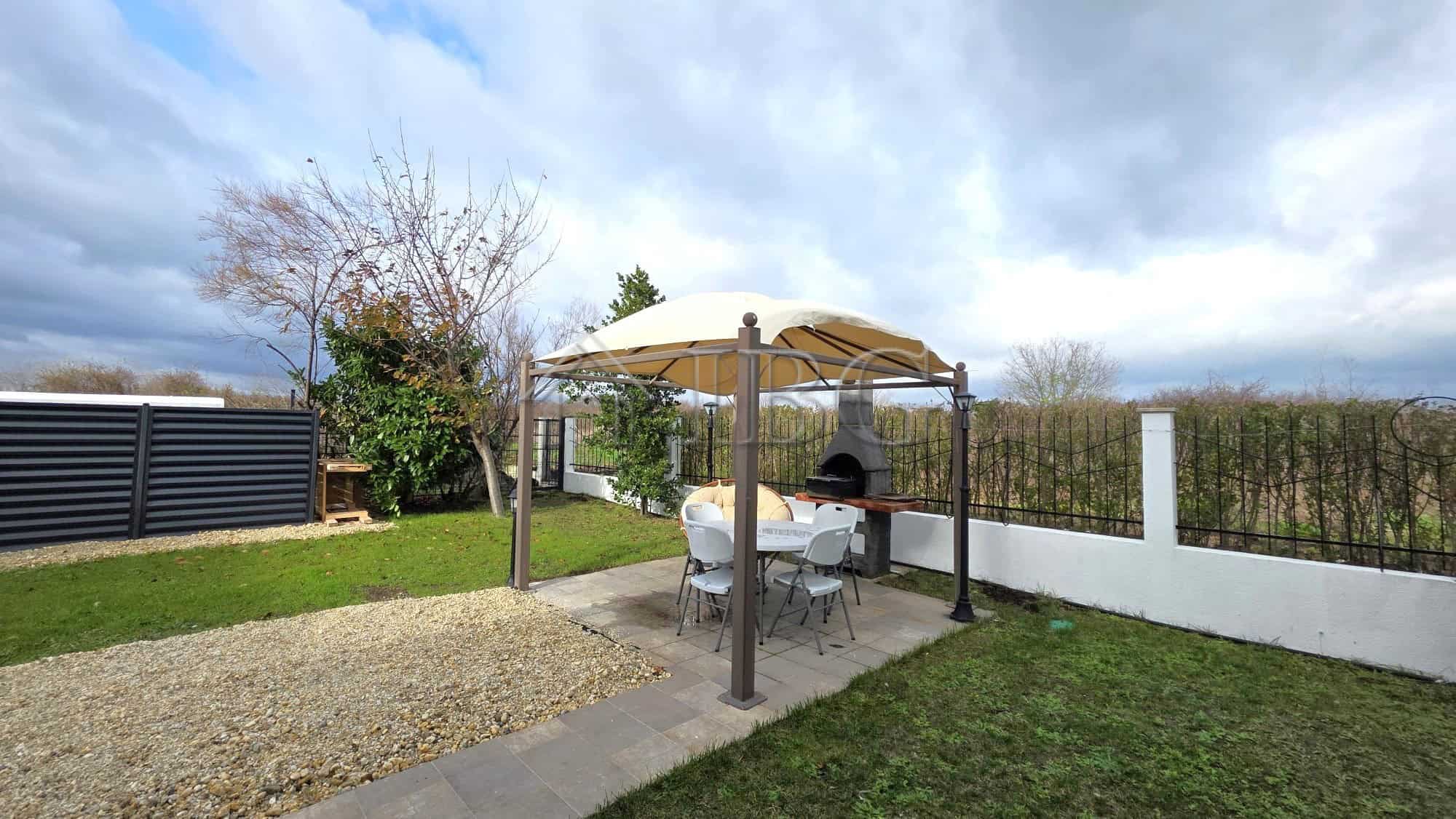 Beautiful outdoor garden area of a luxury villa in Victoria Hill, Pomorie, with a shaded seating are.
