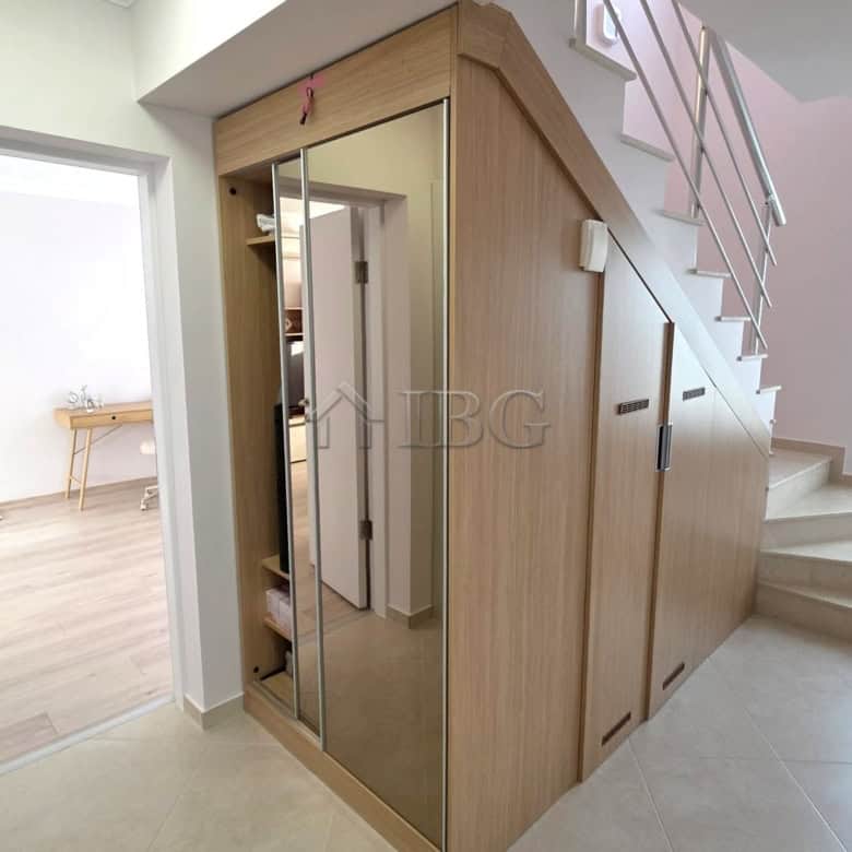 Elegant entrance with mirrored closet and staircase.