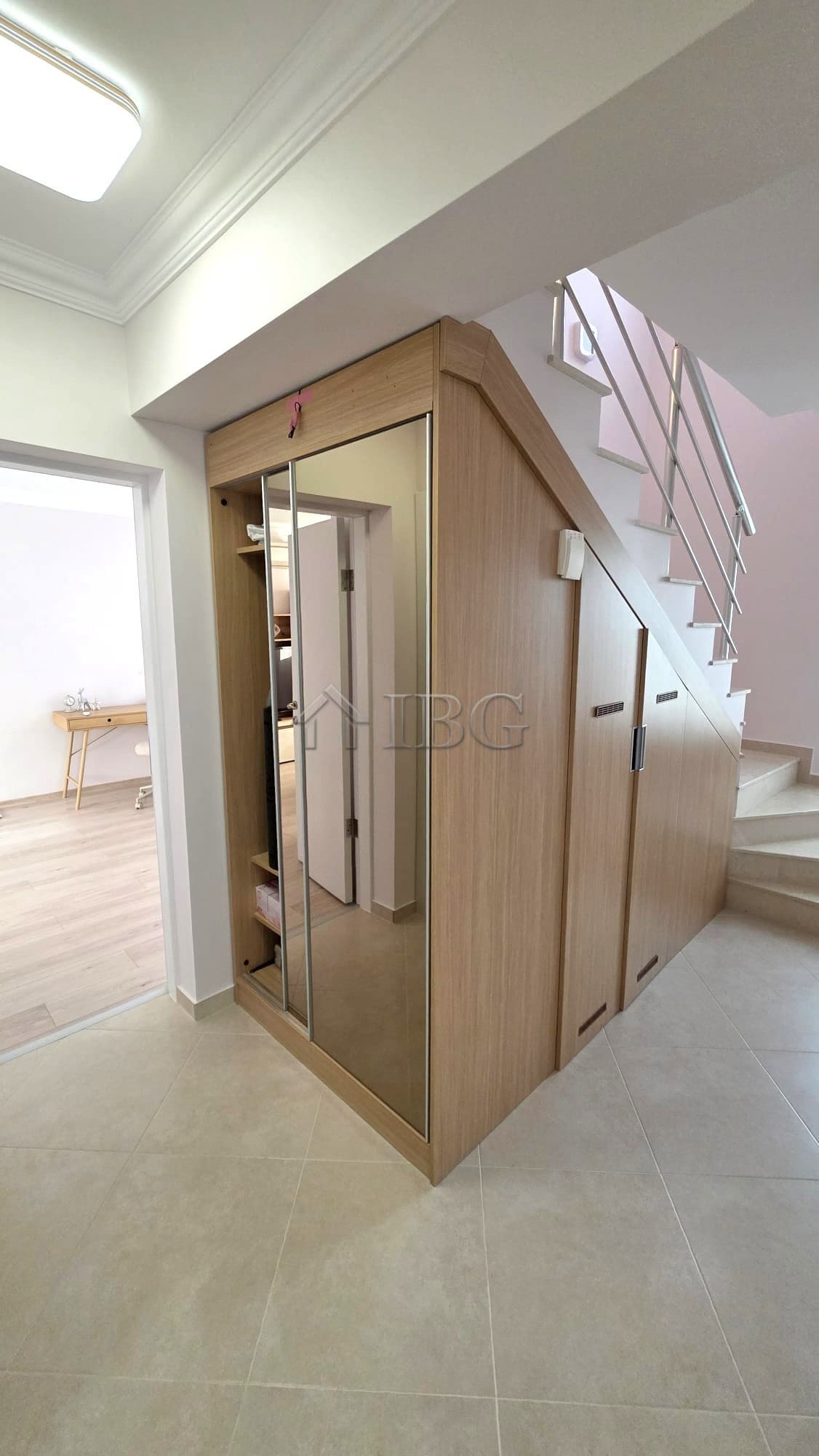 Elegant entrance with mirrored closet and staircase.