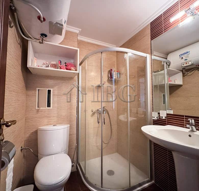 Bright bathroom with shower, toilet, and sink in Sveti Vlas apartment.
