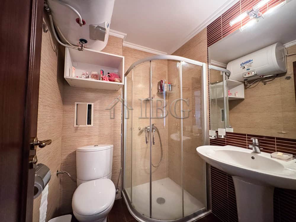 Bright bathroom with shower, toilet, and sink in Sveti Vlas apartment.