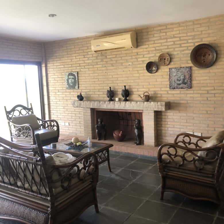 Cozy living room featuring a brick fireplace, vintage furniture, and decorative wall art in a beauti.