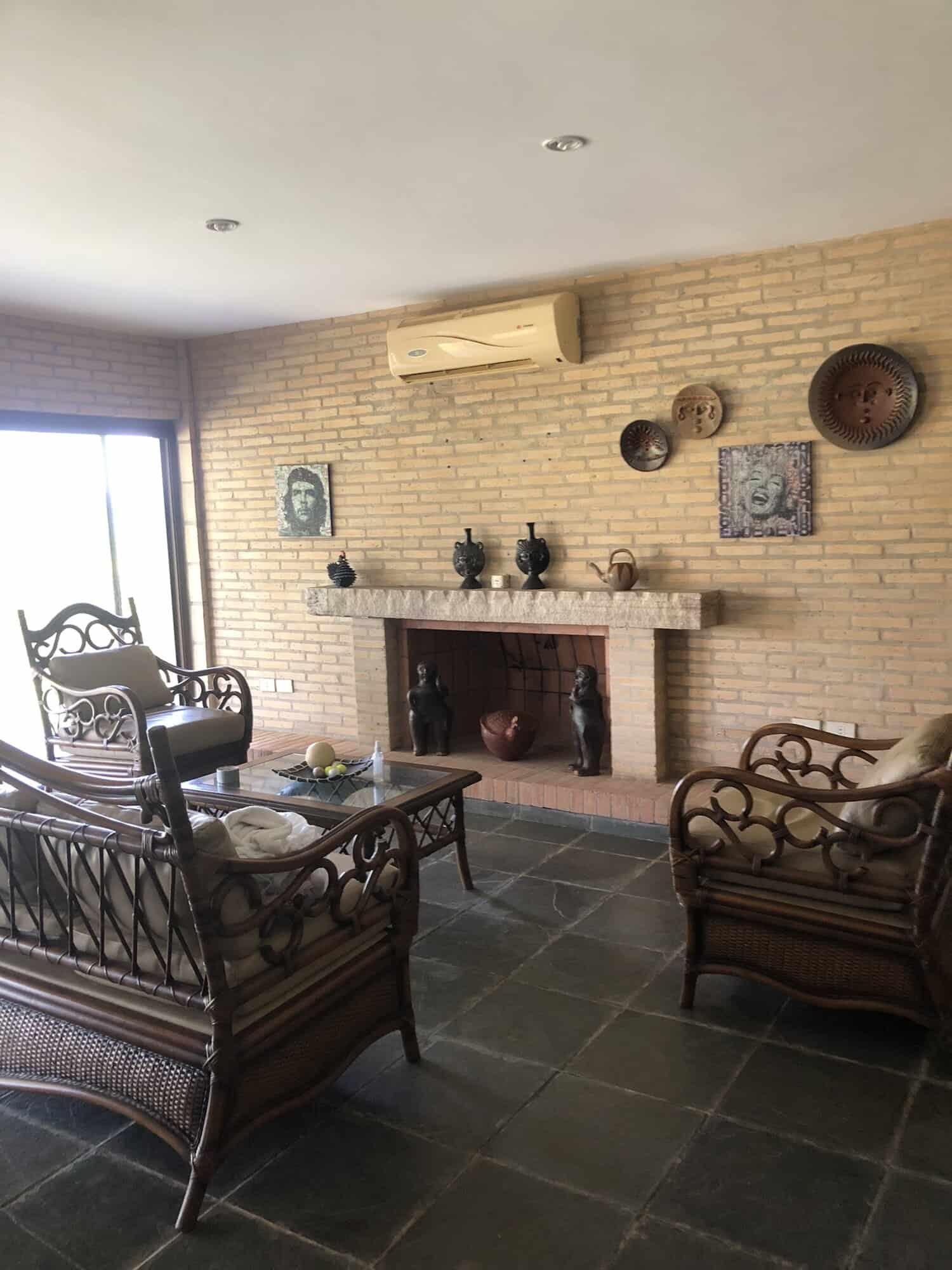 Charming Living Room with Fireplace in Paraguay Cozy living room featuring a brick fireplace, vintage furniture, and decorative wall art in a beauti.