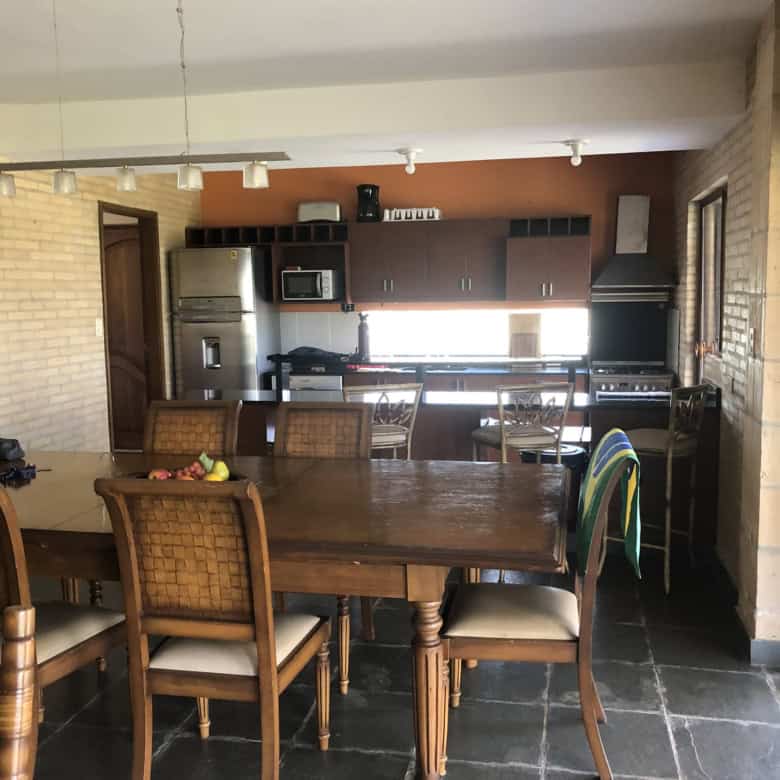 Spacious kitchen with modern appliances and a wooden dining table in a warm, inviting home setting.