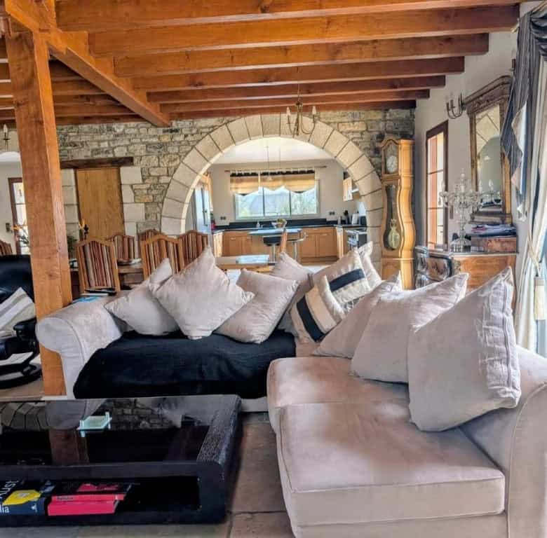 Elegant living room with rustic stone walls and wooden beams in Dordogne Valley, France.