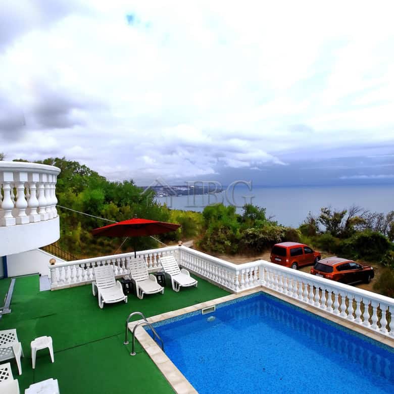 Sea view villa with private pool, outdoor lounging area, and scenic coastal surroundings.